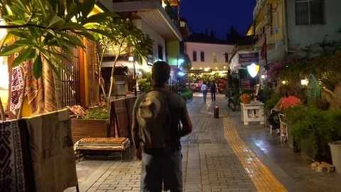 Young Guy With A Backpack Is Walking In A City Street At Night Stockbeeldmateriaal 96729295