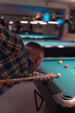 Young guy from behind play billard pool at night Stock Photos
