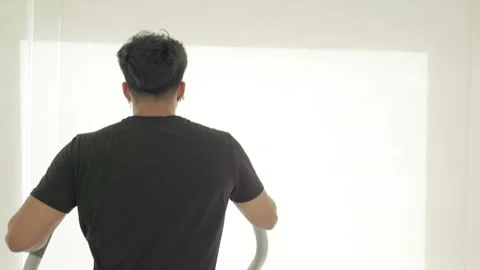 Young guy from behind training with the elliptical machine in the gym. Video stock 244739776
