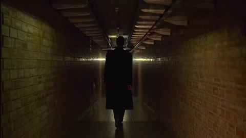 A young guy in a black coat is walking along the corridor Stock Footage 274695266