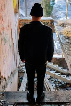Young guy in a black leather jacket stands with his back to the camera Stockfoto's