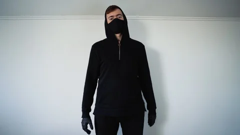 A young guy in black shows a cool hand gesture. White background 库存影片 129555571