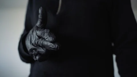 A young guy in black shows a hand gesture. White background 库存影片 129555978