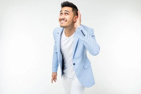 Young guy in a blue jacket overhears a conversation on a white background with Photos