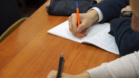 Young guy bored of sitting at the table. The student decided to do nothing in th Stock Footage 100033450