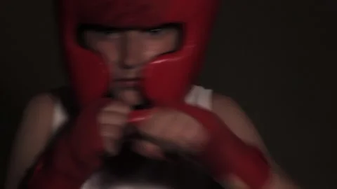Young guy boxer in a red protective helmet posing at the camera close-up in band Stock Footage 201024793
