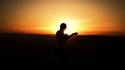 Young guy boxing at sunset in the mountains Stock Footage 108188726