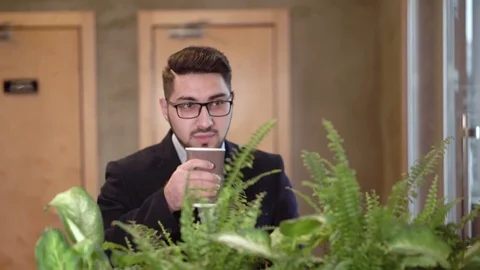 Young guy brunette in glasses drinks coffee Stock Footage 85404451