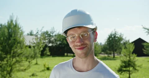 Young guy builder architect smiling smiling happily looking at camera in white Stock Footage 142255877