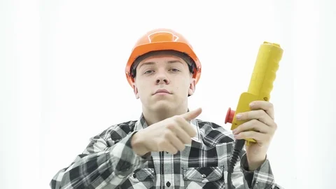 Young guy in builder costume presses the red button with his thumb Stock Footage 107009068