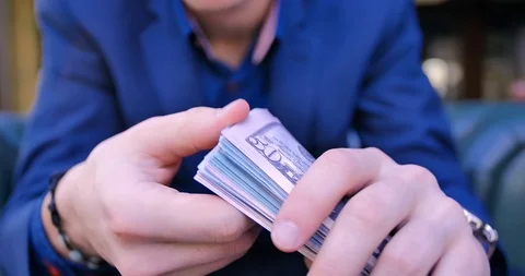 Young guy businessman freelancer counts money. Close-up hands counting a stack Stock Footage 113102308