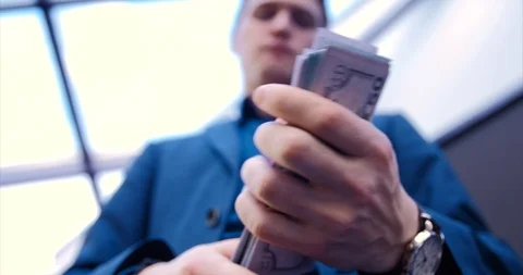 Young guy businessman freelancer counts money. Close-up hands counting a stack Stock Footage 113102385