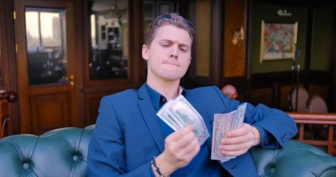 Young guy businessman freelancer counts money. Dollars, income, finance Stock Footage 113102386
