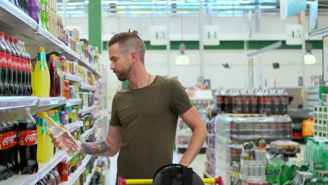 Young guy buying soda drinks at grocery store Stock Footage