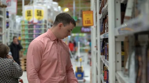 Young guy buys coffee beans in a store or supermarket. Stock-Footage 80359166