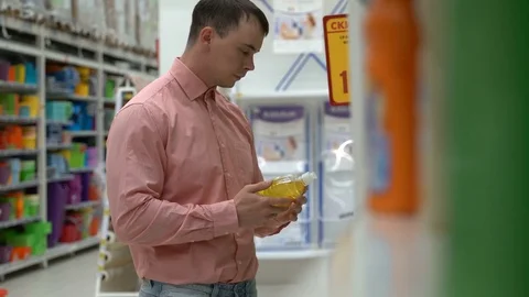 Young guy buys liquid soap in a store or supermarket. Stock-Footage 80505263