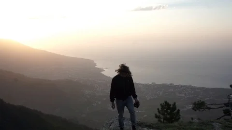 Young guy with a camera climbs the mountainside Stock-Footage 102696992