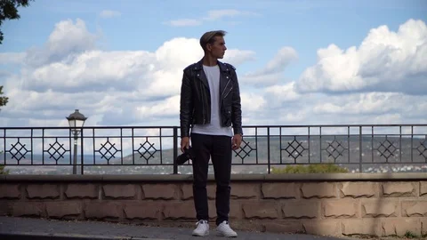 A young guy with a camera looks at the sides Stock Footage 119712821