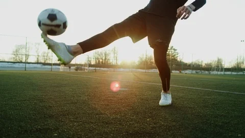 A young guy in a cap throws a soccer ball with his knees. Street football Video stock 114132163