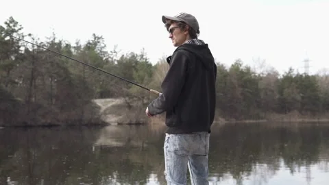 A young guy catches a predatory fish on spinning from the shore. Stock Footage 173713258