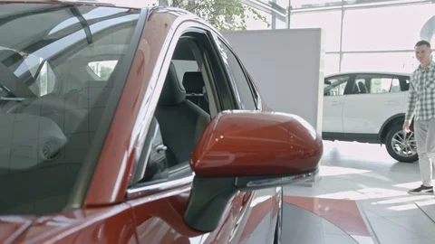 Young guy is choosing new automobile walking around luxury car and touching it Stock Footage 101110615