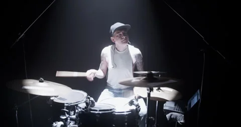Young guy with closed eyes playing drums on stage Stock Footage 249853161