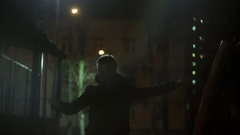 Young guy in a coat performs movements Stock Footage 77377390