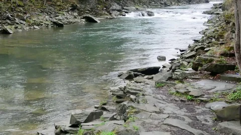 A young guy comes with a backpack to a mountain river Video stock 83431658