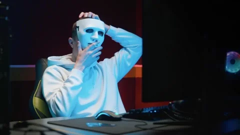 A young guy at the computer puts on a mask Video stock 158959775