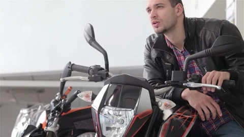 Young guy confidently turning the handlebar of a sleek motorcycle Video stock 311926837
