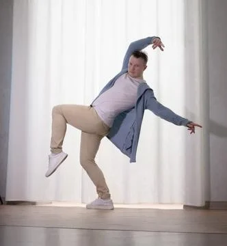 Young guy dancer in motion in a pose. A man performs a modern dance in casu.. Stock Photos