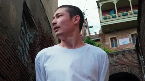 A young guy dances against the background of an authentic city landscape.  Stock Footage 242145960