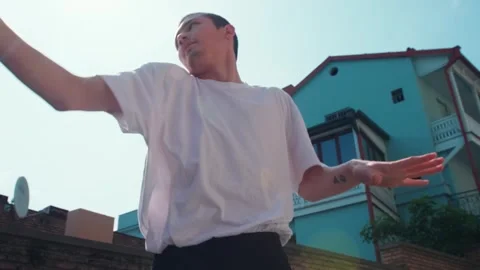 A young guy dances against the background of an authentic city landscape.  Stock Footage 242147180