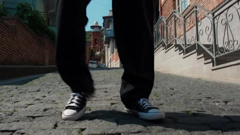 A young guy dances against the background of an authentic city landscape.  Stock Footage 242147329
