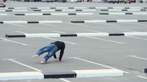 Young guy dancing hip hop in the car parking. Slow motion Stock Footage 138808530