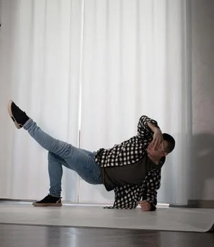 Young guy in a dancing pose on a white background. Modern dance in a plaid .. Stock Photos