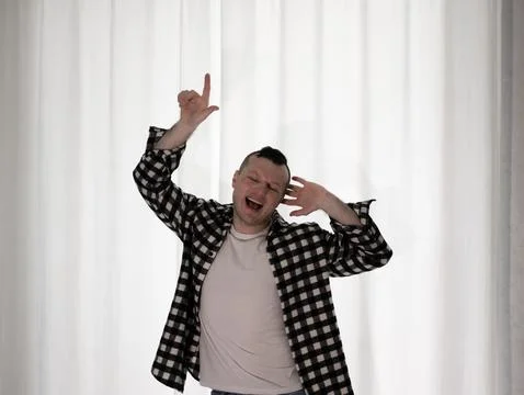 Young guy in a dancing pose on a white background. Modern dance in a plaid .. Stock Photos