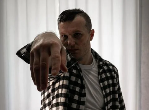 Young guy in a dancing pose on a white background. Modern dance in a plaid .. Stock Photos