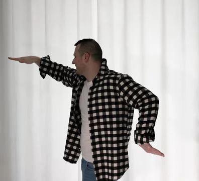 Young guy in a dancing pose on a white background. Modern dance in a plaid .. Foto stock