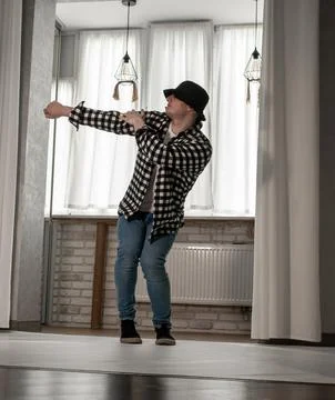 Young guy in a dancing pose on a white background. Modern dance in a plaid .. Foto stock