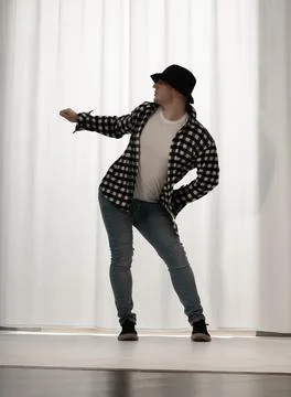 Young guy in a dancing pose on a white background. Modern dance in a plaid .. Foto stock