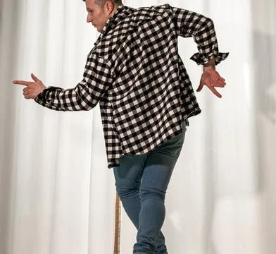 Young guy in a dancing pose on a white background. Modern dance in a plaid .. Stock Photos