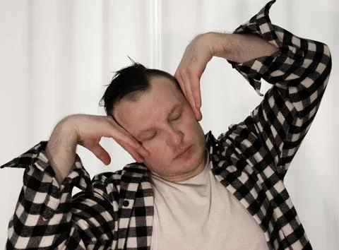 Young guy in a dancing pose on a white background. Modern dance in a plaid .. Stock Photos