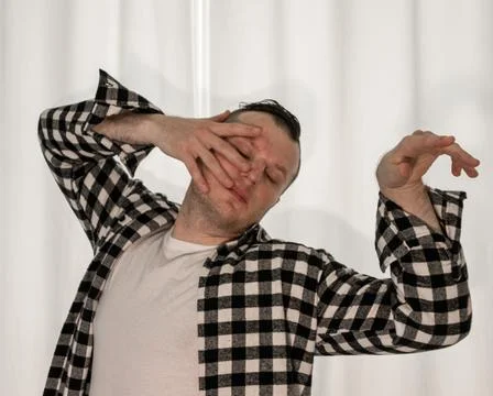 Young guy in a dancing pose on a white background. Modern dance in a plaid .. Stock Photos