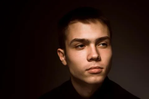 Young guy on a dark studio background Stock Photos