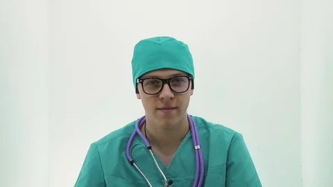 Young guy in a doctor's costume is smiling and spinning Stock Footage 107008999