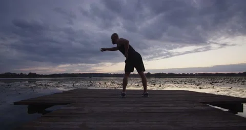A young guy does sports by stretching his muscles Stock Footage 224873019