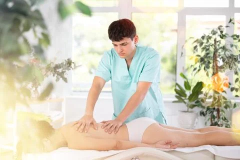 Young guy doing a back massage to adult woman Foto stock