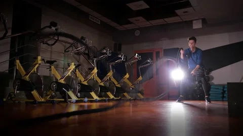 Young guy is doing an exercise with rope in gym with beautiful, contour light 4K Stock Footage 168969576