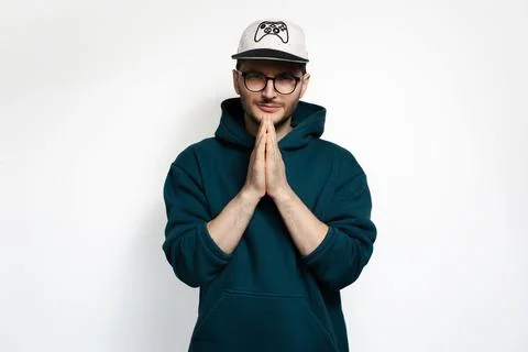 Young guy doing pray gesture with hands, isolated on white background. Stock Photos